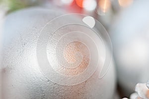 Abstract blurred christmas background. Close-up silver ball in foreground, golden bokeh and copy space.