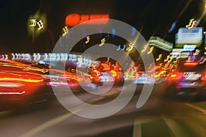 Abstract blurred colorful background of urban street night traffic with bokeh lights. Auto, city street lights, speed