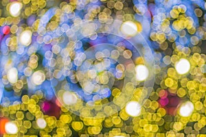 Abstract blurred colorful Christmas tree lighting decoration with bokeh background. Defocused of decorated and illuminated christm