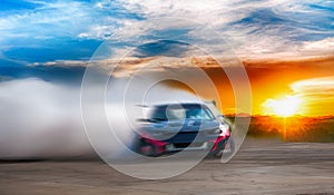 Abstract blurred drift car with smoke from burned tire at sunset