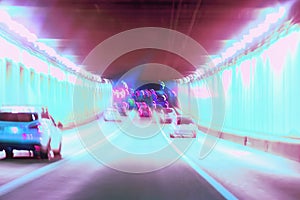 Abstract blurred driving in the tunnel at night, moving cars, urban street illumination. Concept of modern lifestyle of
