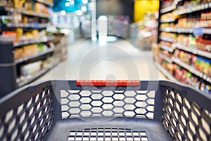 Abstract blurred photo of empty trolley in supermarket bokeh background. Empty shopping cart in supermarket