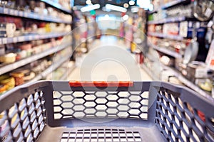 Abstract blurred photo of empty trolley in supermarket bokeh background. Empty shopping cart in supermarket