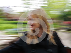 Abstract blurred portrait of blond woman in spinning ride