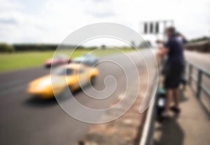 Abstract blurred race cars with people watching the speed past