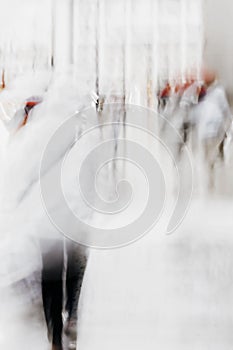 Abstract blurred silhouettes of people hurrying down city street in rainy day. Concept of weather, modern city