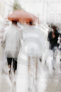 Abstract blurred silhouettes of people in rain. Concept of weather, seasons, modern city