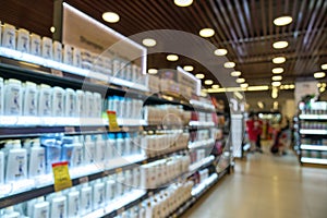 Abstract blurred supermarket aisle with colorful shelves and unrecognizable customers as background