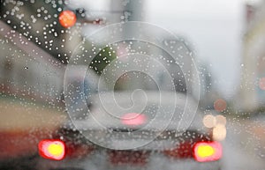 Abstract blurred traffic in raining day with road view through car