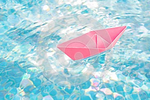 Abstract boat travel concept paper ship origami boat toy paper sailboat. Floating in water pink paper boat water