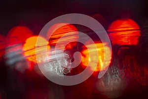 Abstract bokeh caused by rain drops reflecting onto car windscreen from car