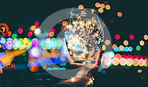 Abstract bokeh of festive lights through a glass jar at twilight