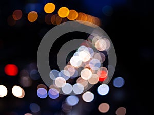Abstract bokeh night light background, blurred lights traces from cars on road, defocused city traffic on street at night