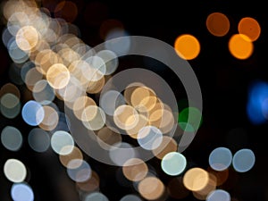 Abstract bokeh night light background, blurred lights traces from cars on road, defocused city traffic on street at night