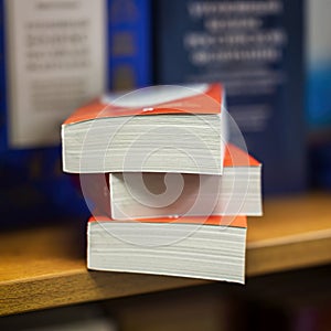 Abstract bookstore. Book stack on wood bookshelf, blurred background