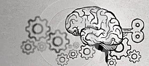 Abstract brain sketch with wind-up mechanism and gears on concrete wall background. Intelligence, strategy, knowledge, psychology