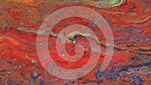 Abstract bright red and light pastel streams flow across the plane on a blue background. Marble texture. Fluid art