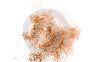 Abstract brown powder splattered on white background.Abstract design of color dust cloud against white background