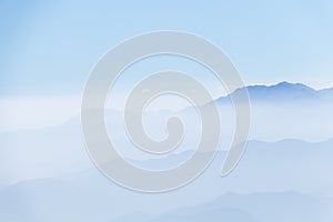 Abstract cascade mountain chains silhouette landscape nackground in a light blue mist sky in morning Andes