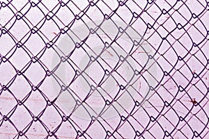 abstract chain link fence texture against grungy color wall.