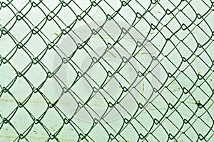 abstract chain link fence texture against grungy color wall.