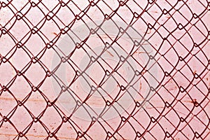 abstract chain link fence texture against grungy color wall.