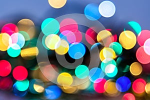 Abstract Christmas and carnival background with colorful bokeh lights of garland, red, green, blue, yellow colors of New Year with