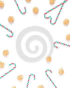 Abstract Christmas composition. Yellow bows and candy canes are on a white background. Flat lay, top view, copy space
