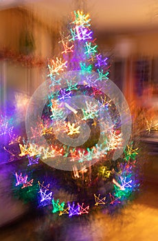 Abstract christmas neon background. Blurred garlands of lot of multicolored neon glowing stars on Christmas tree