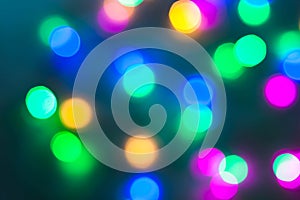 Abstract Christmas New Year garland multicolored neon ights close up blurred bokeh dark background