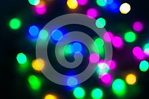 Abstract Christmas New Year garland multicolored neon ights close up blurred bokeh dark background