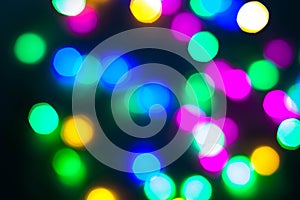 Abstract Christmas New Year garland multicolored neon ights close up blurred bokeh dark background