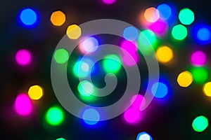 Abstract Christmas New Year garland multicolored neon ights close up blurred bokeh dark background