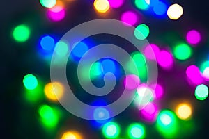 Abstract Christmas New Year garland multicolored neon ights close up blurred bokeh dark background