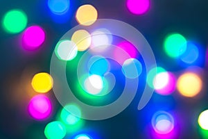 Abstract Christmas New Year garland multicolored neon ights close up blurred bokeh dark background