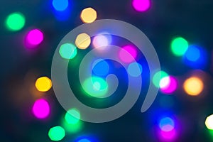 Abstract Christmas New Year garland multicolored neon ights close up blurred bokeh dark background