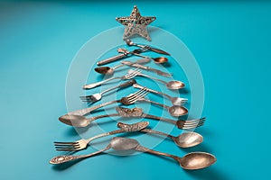 Abstract Christmas tree made from blue background. Top view . tree of knives and forks with a star