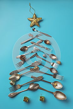 Abstract Christmas tree made from blue background. Top view . tree of knives and forks with a star