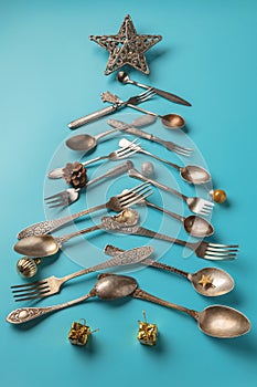 Abstract Christmas tree made from blue background. Top view . tree of knives and forks with a star