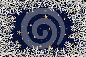 Abstract Christmas winter background made of white corals and starfish snowflakes against dark blue background