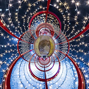 Abstract circular orb in festively lit underground passage tunnel with red frame arch