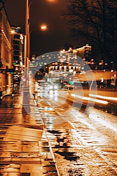 Abstract city at night, blurred auto cars with bright lights, city street lights, traffic speed, night time