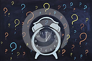 Abstract clock and question marks sketch on chalkboard wall background. Time management concept