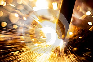 Abstract close-up image of blurred sparks and smoke from arc welding with bokeh effect