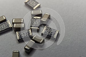 Abstract close-up scattered 0603 SMT MLCC capacitors, resistors electronics components white background random pattern