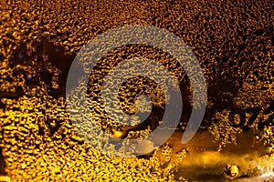 Abstract close up shot of backlit condensation on beer bottle /