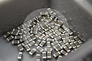 Abstract close-up 0603 SMT surface mount MLCC capacitors electronics components random scatter in storage container