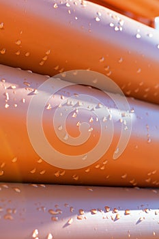 Abstract close up of a stack of orange plastic pipes on construction