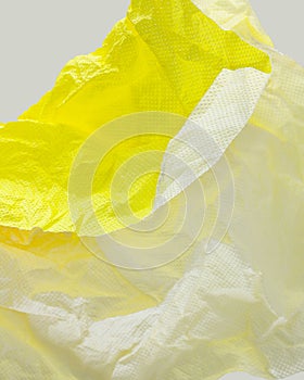 An abstract closeup of crushed paper in yellow and white. .