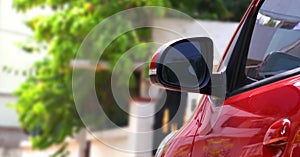 Abstract closeup of side rearview mirror on a red modern car